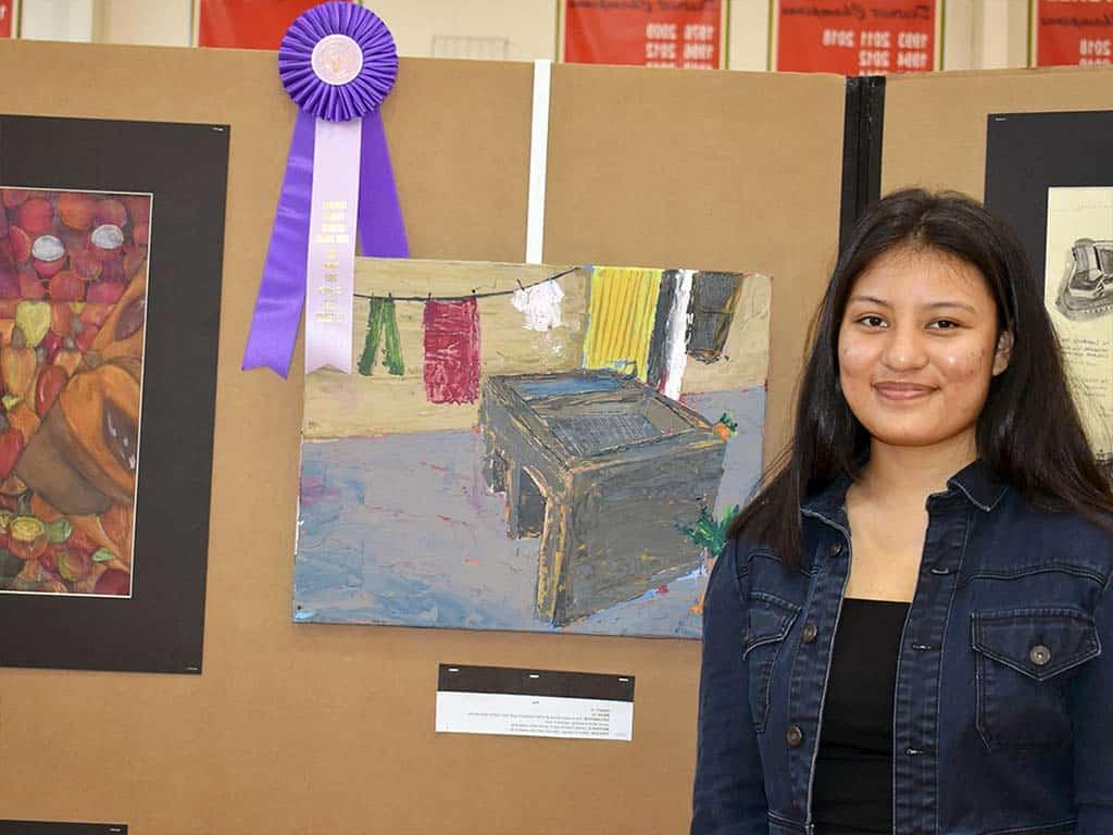 Art student posing with her art and ribbon