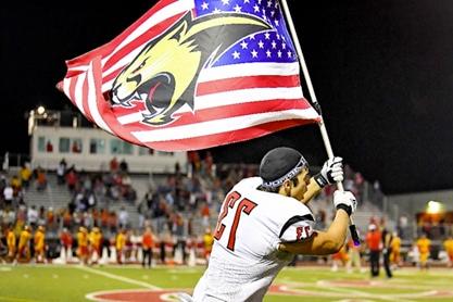 Football player waving American flag with cougar symbol